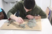 Miniature d'un jeune réalisant un bas-relief en carton pâte au cours de l'atelier d'Arts plastiques avec Karine Bracq