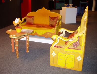 Salon carton pâte de Karine Bracq avec son canapé, son fauteuil et sa table ornée d'une fleur décorative en plâtre de sculpture